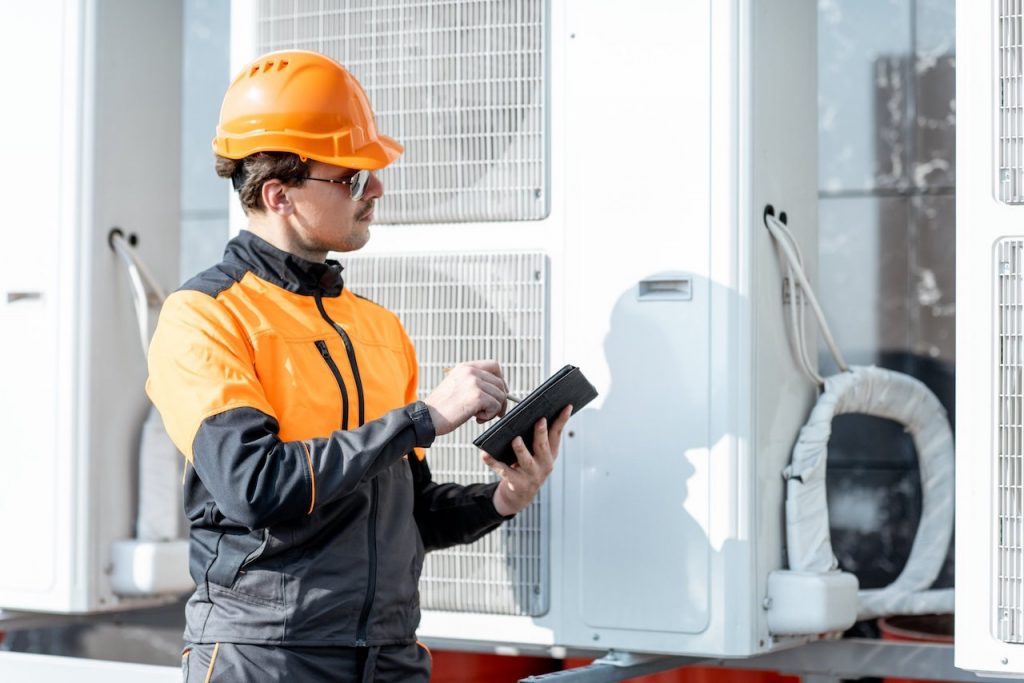 man performing commercial heat pump maintenance